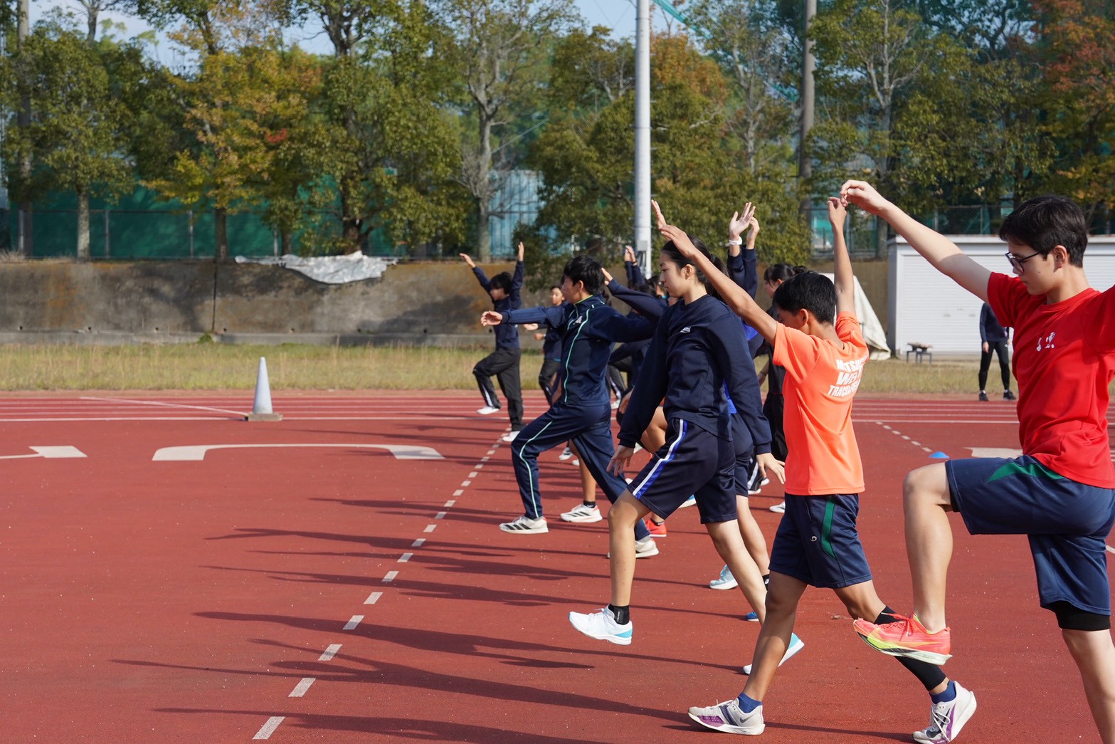 陸上トラックでウォームアップする選手たち